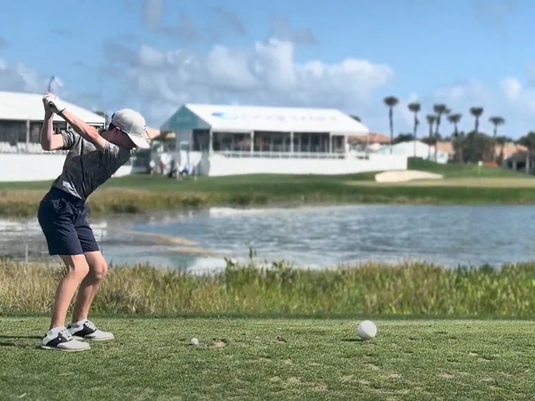 Person planning junior golf tournament schedule on calendar